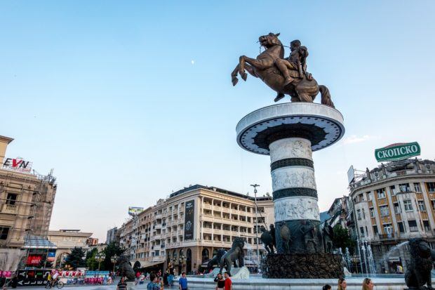 Statue of a man on a horse on top of a pedestal in a city square