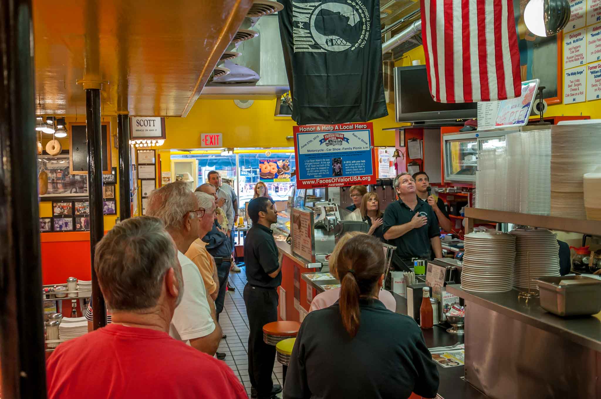 People saying the Pledge of Allegiance in a restaurant.