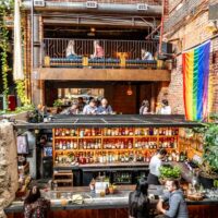 People sitting at a multi-level bar with exposed brick walls