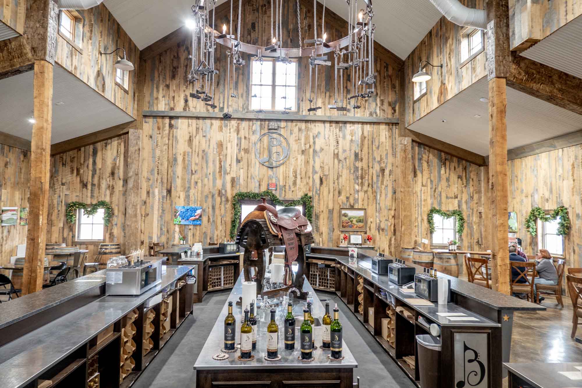 Large room with wood paneling and a bar for wine tasting at the center