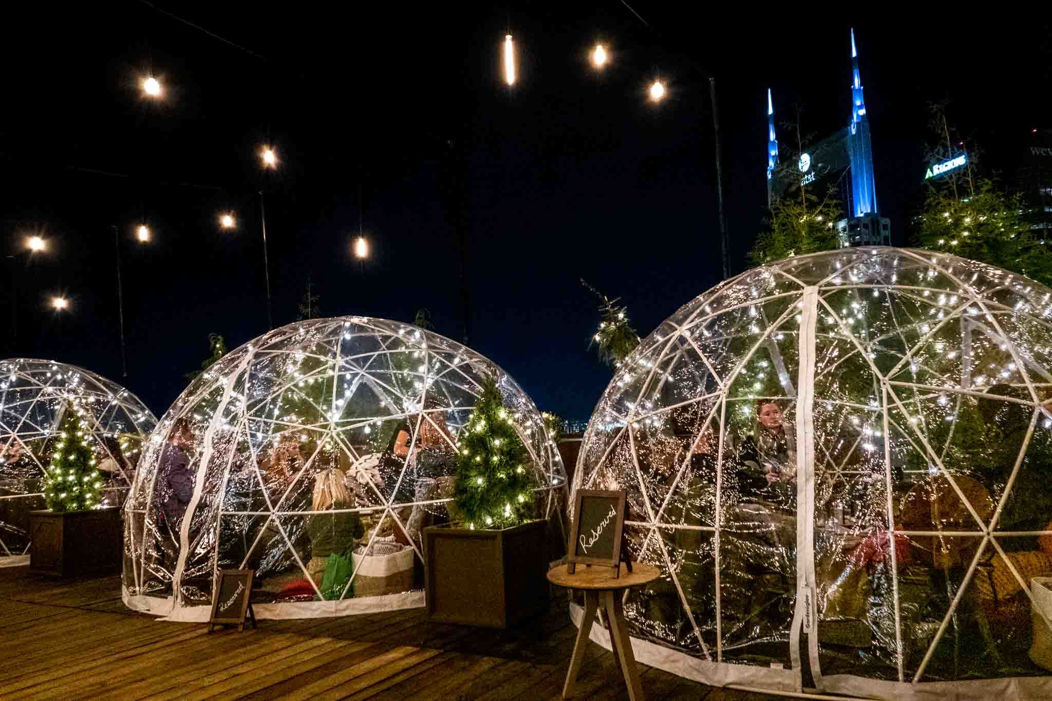 Igloo tents at night on a deck.