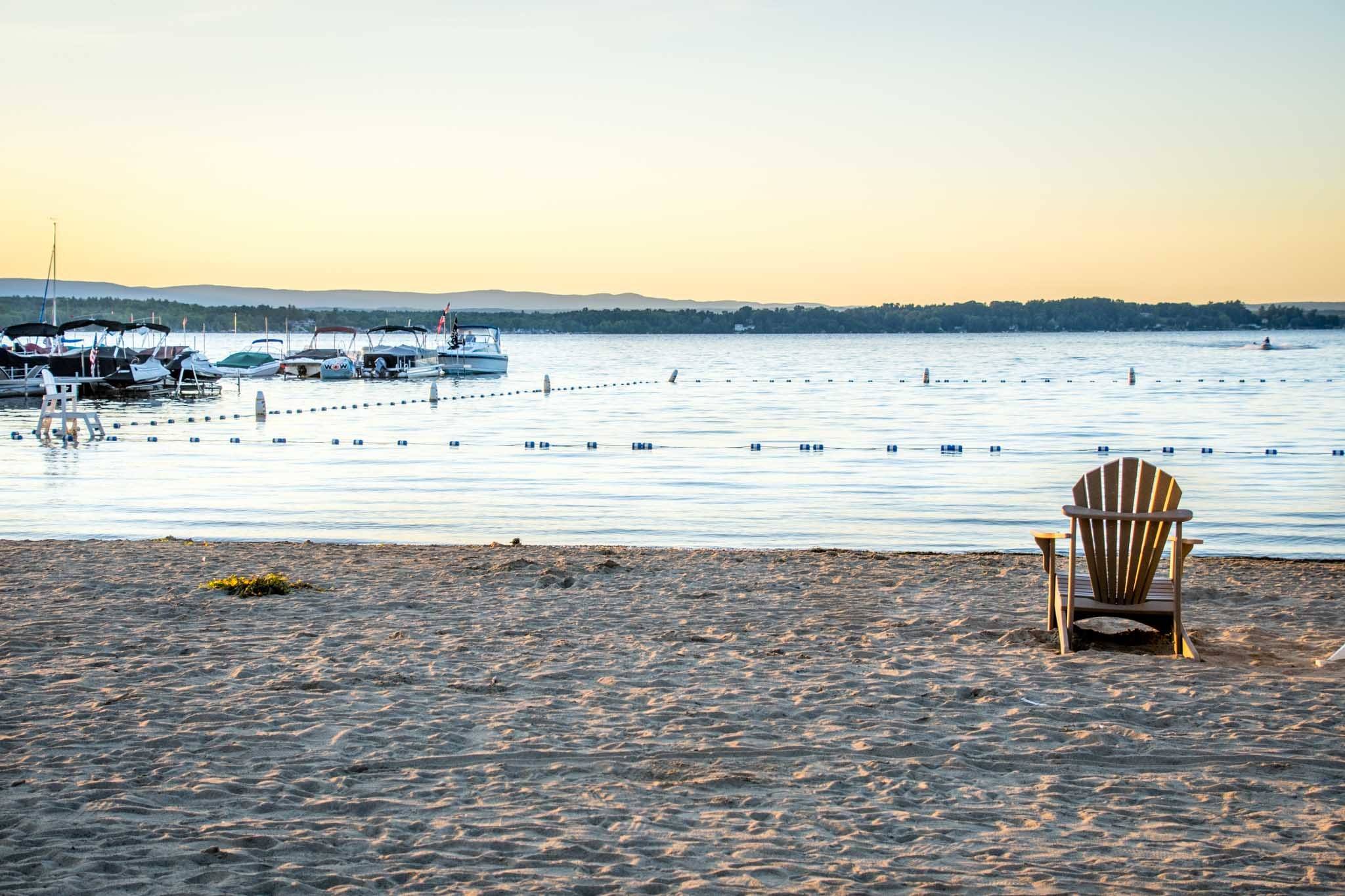 Adirondak chair on a beach by the water
