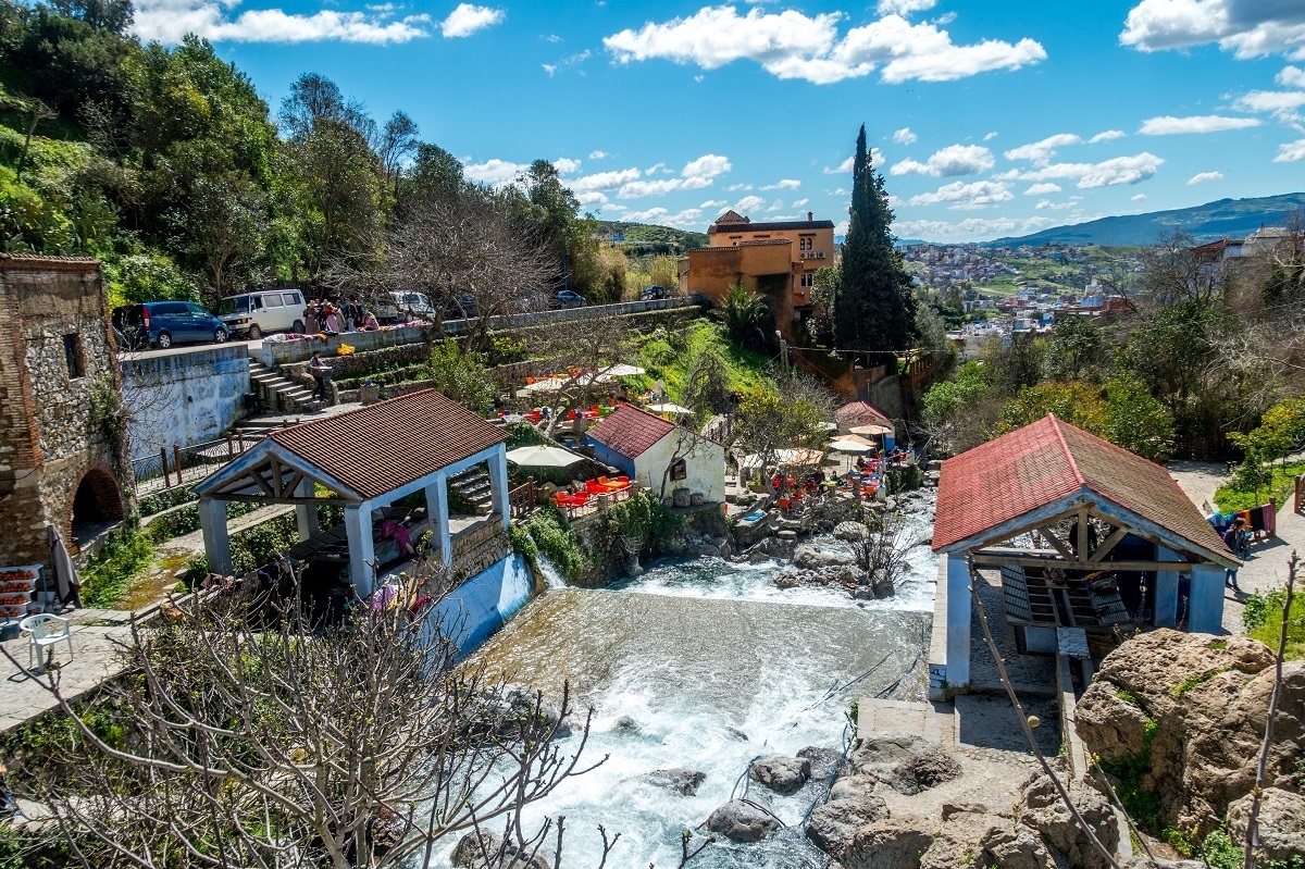 Waterfall and cars on road nearby