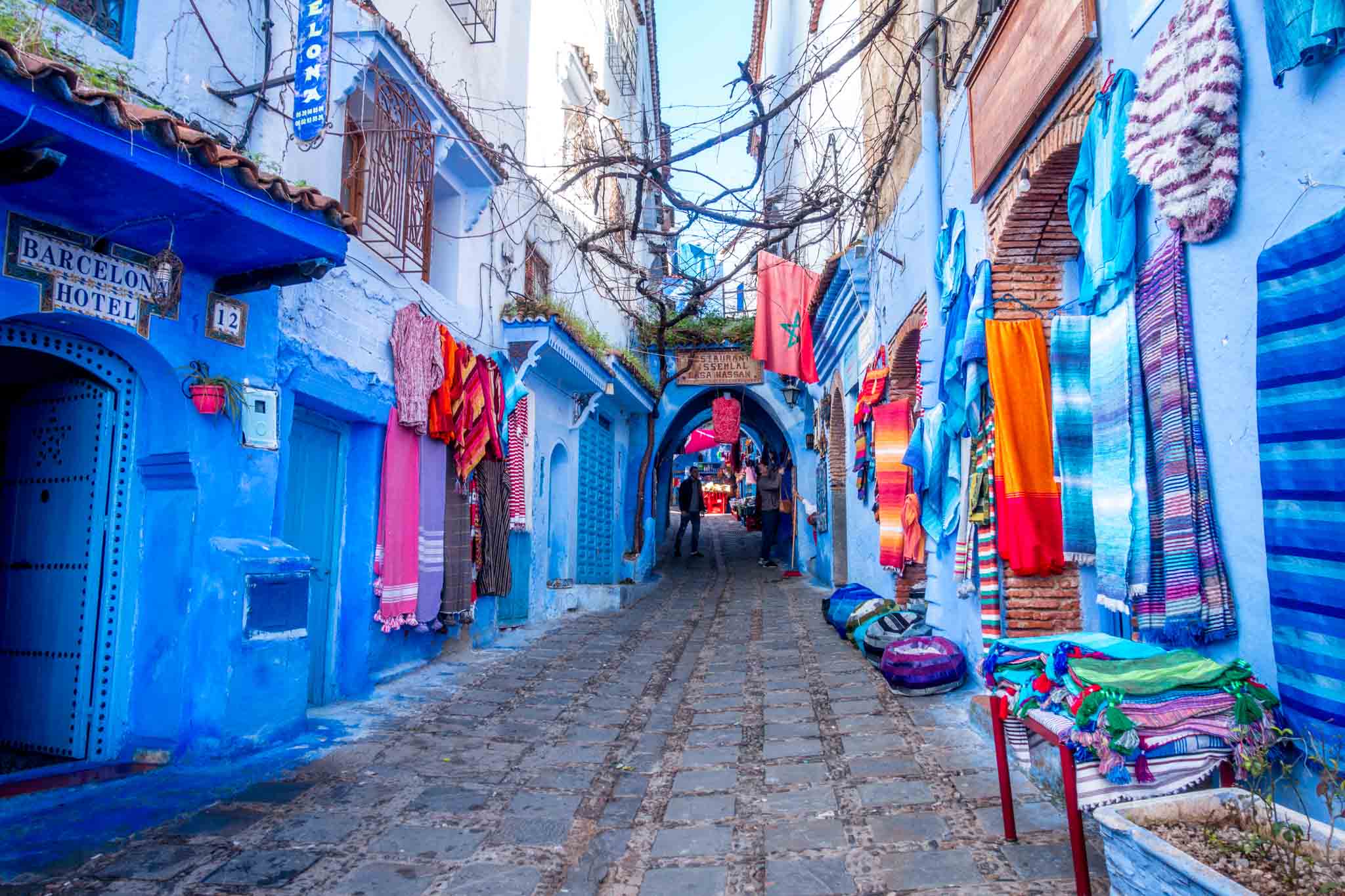 Bright rugs hanging on blue walls