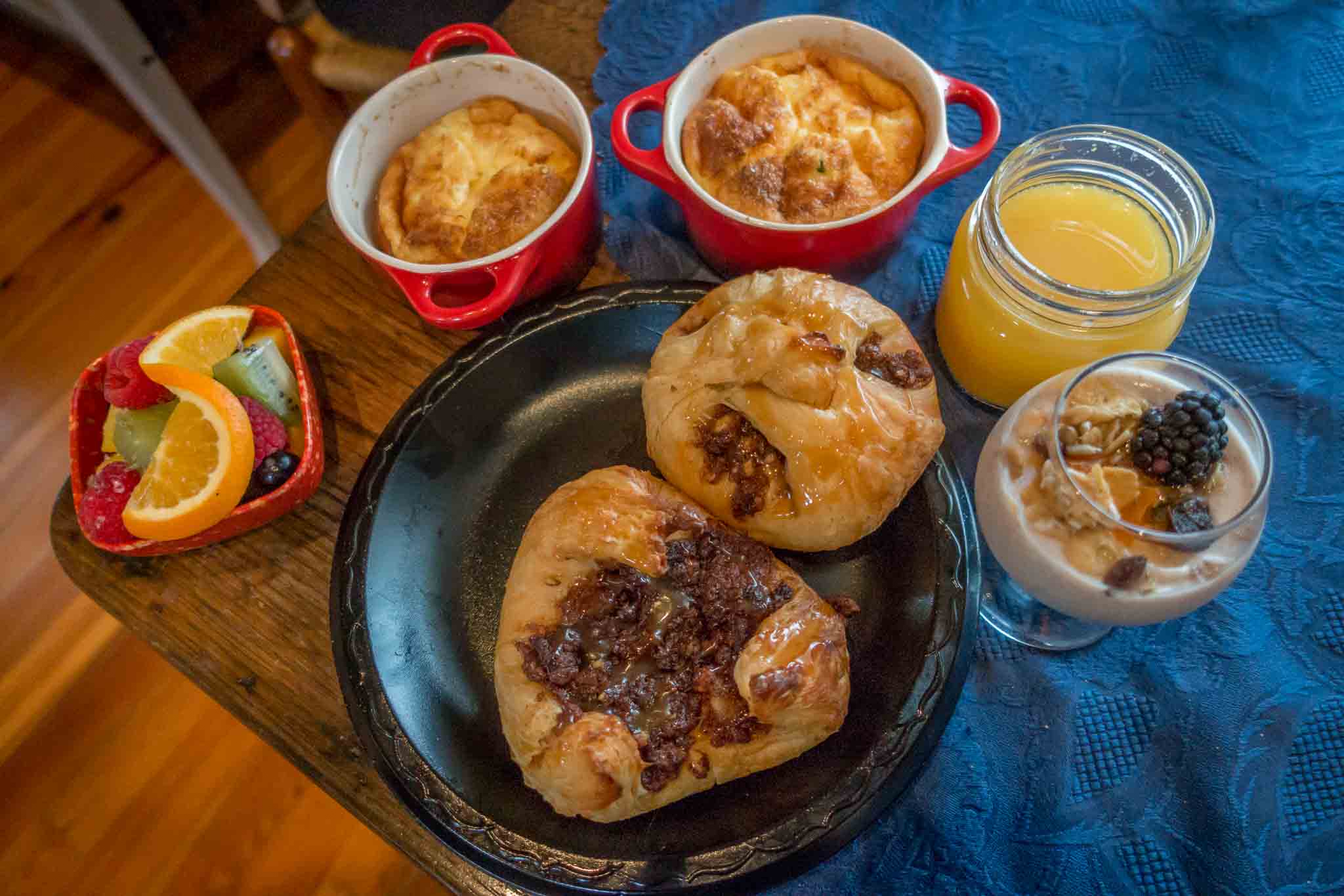 Pastries, souffles, yogurt, fruit, and orange juice on a table