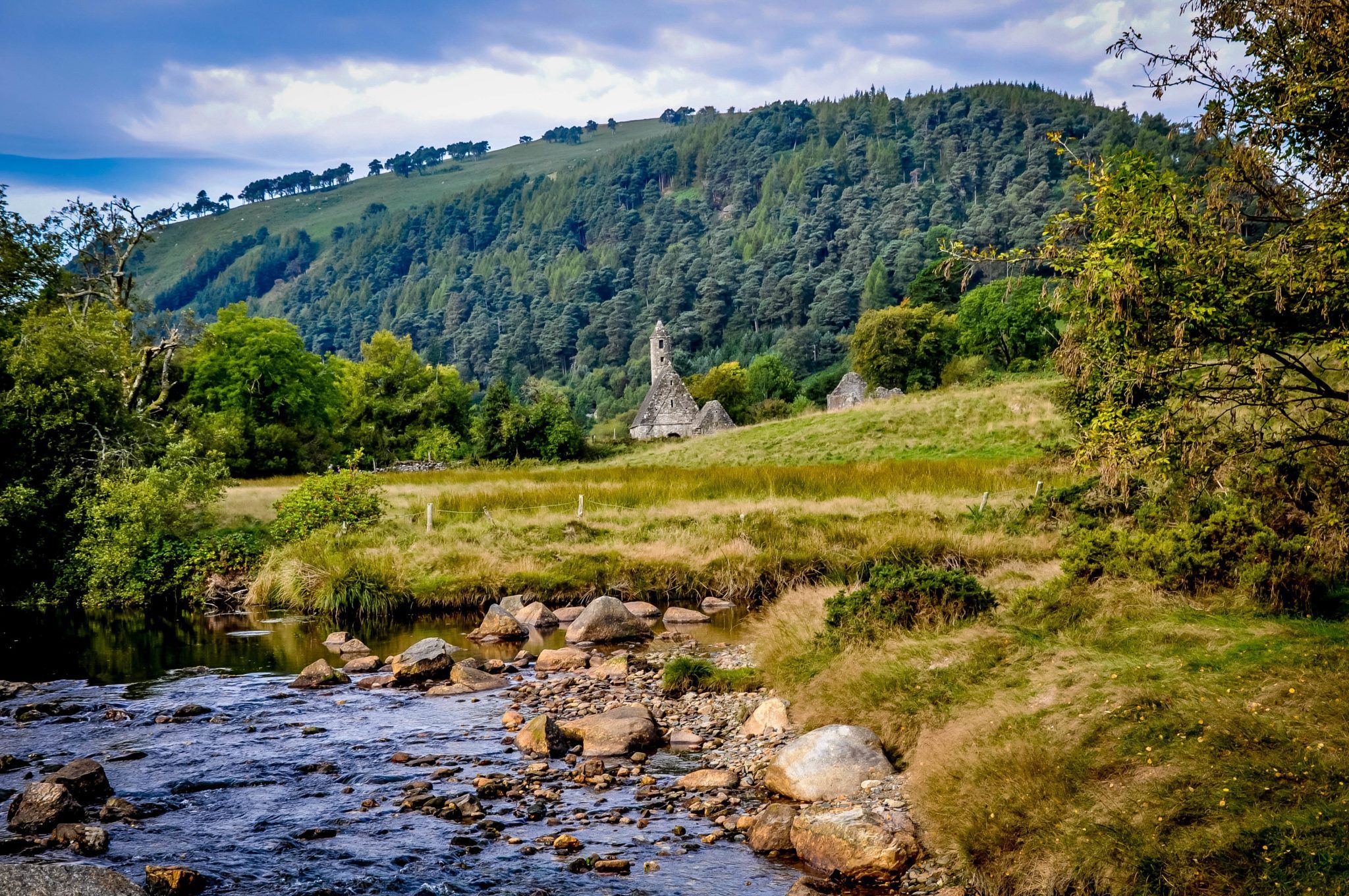 Stone building at the base of a hill beside a stream