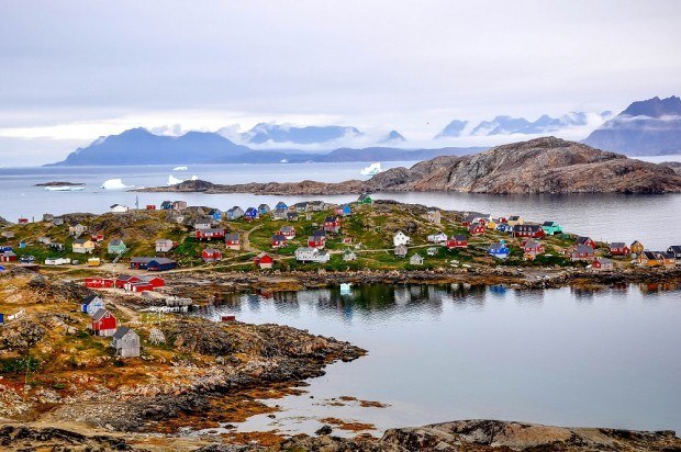 Colorful houses along a coastline with snow-covered mountains