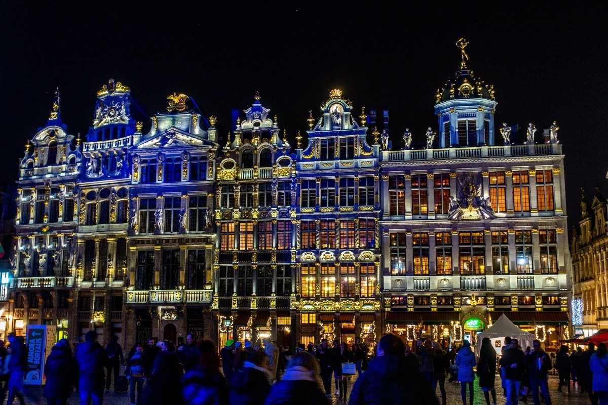 Crowd watching light show on the exterior of historic buildings. 