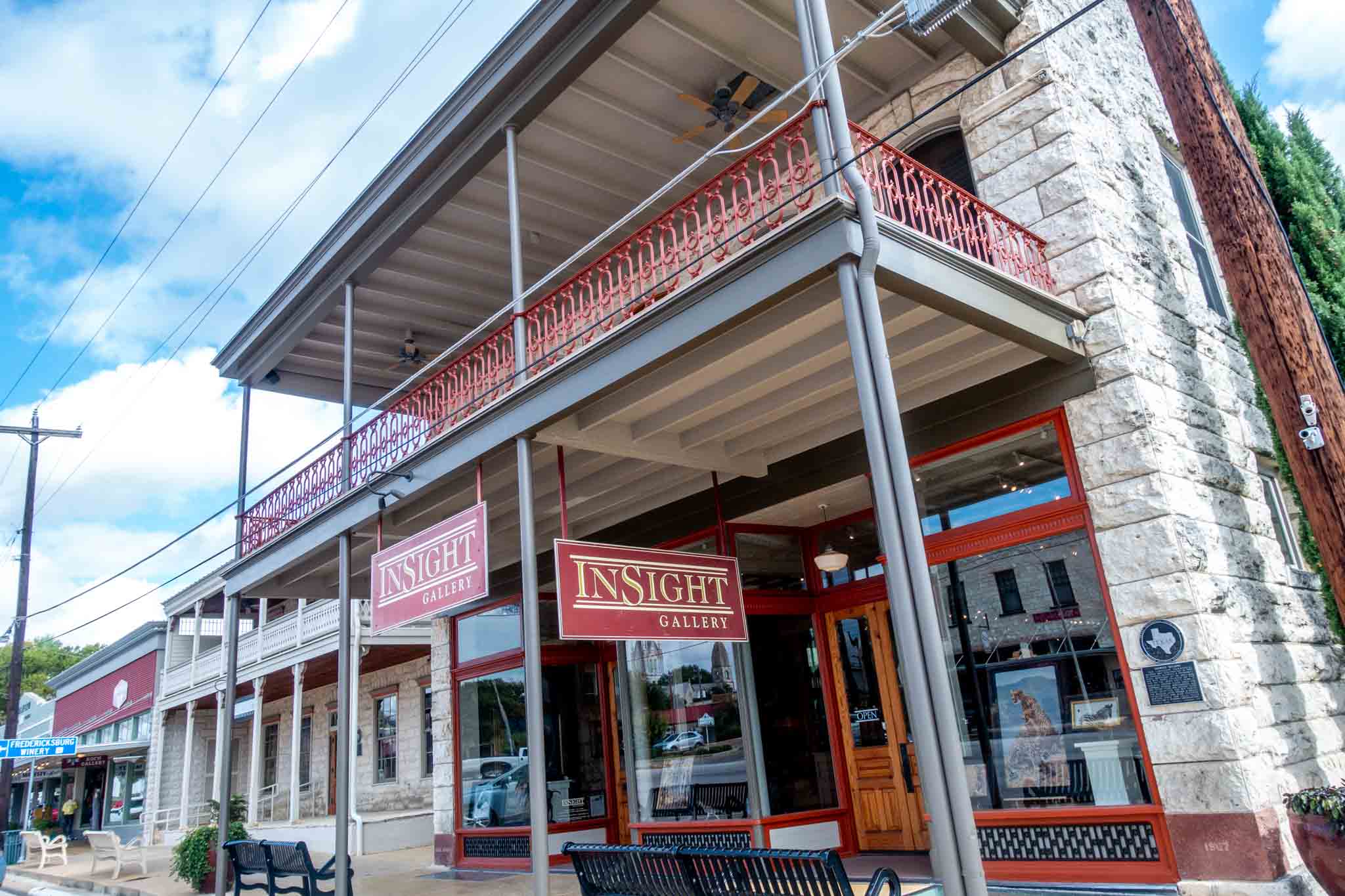 Exterior of a 2-story building with wrought-iron balcony.