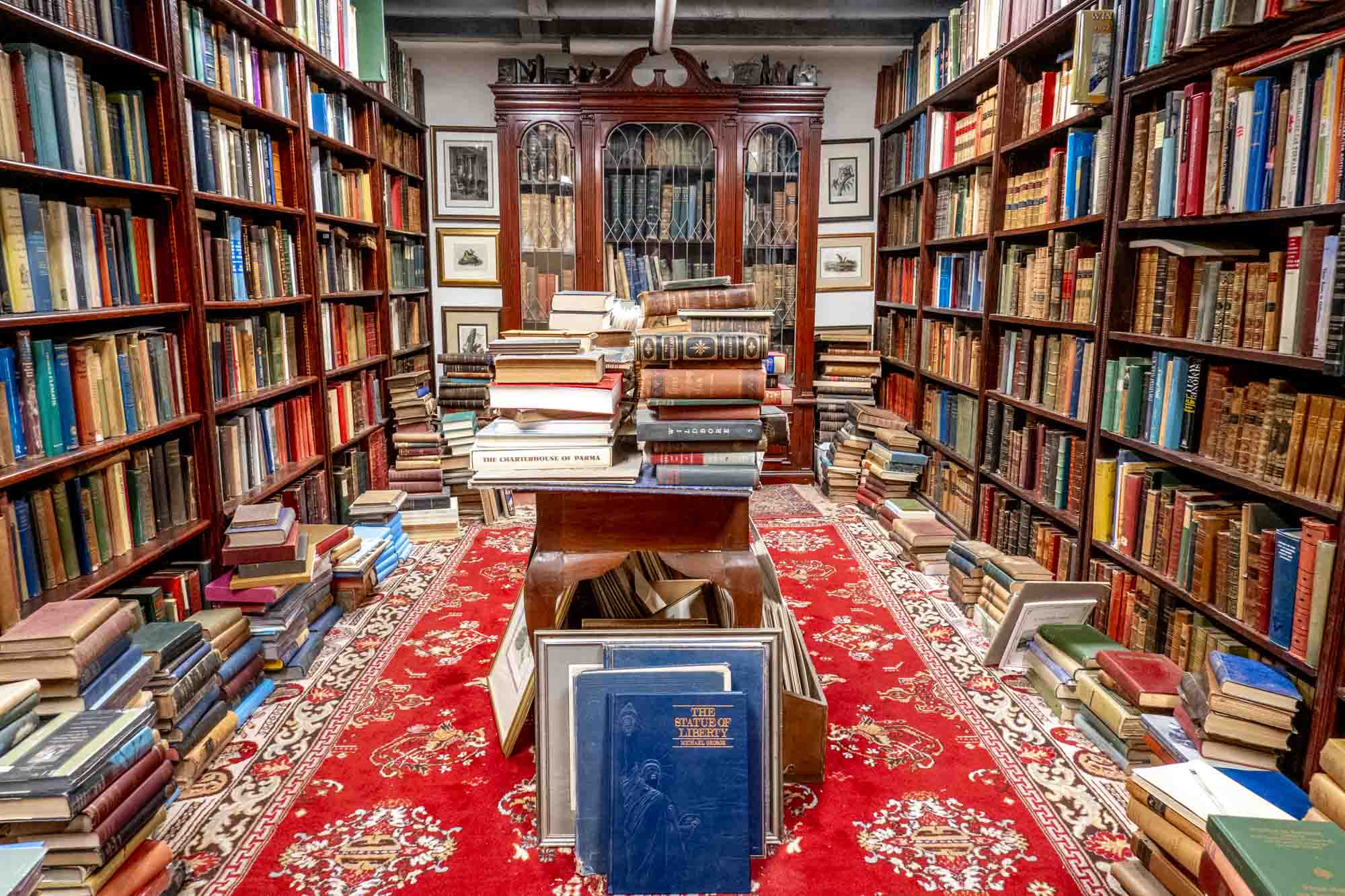 Room full of shelves and tables stacked with books