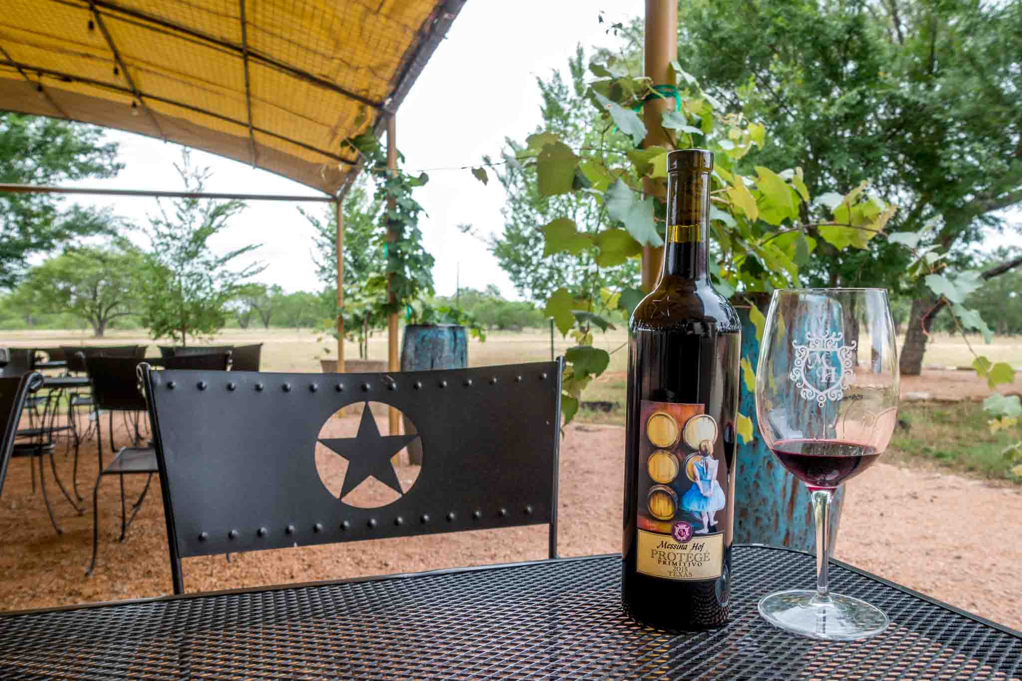 Wine glass and bottle on a table outside