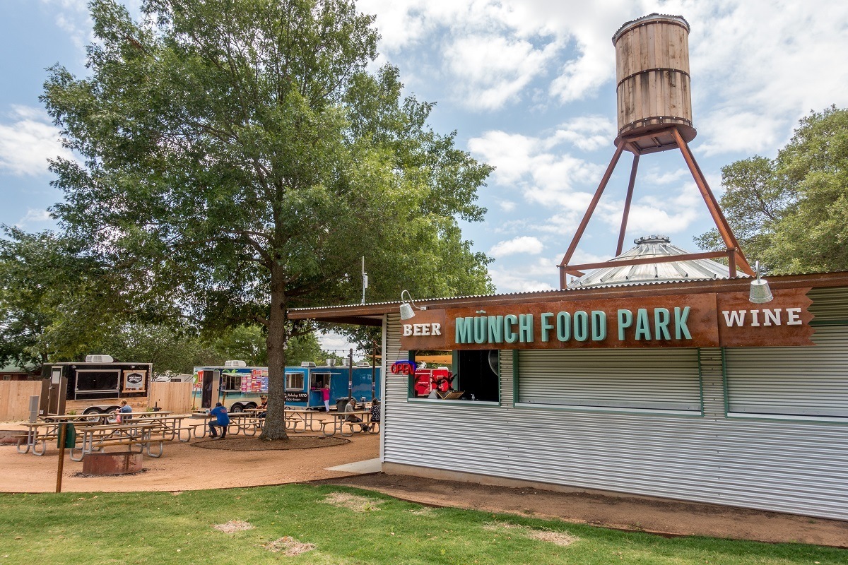 Food trucks and a kiosk with a sign: Munch Food Park, beer, wine.