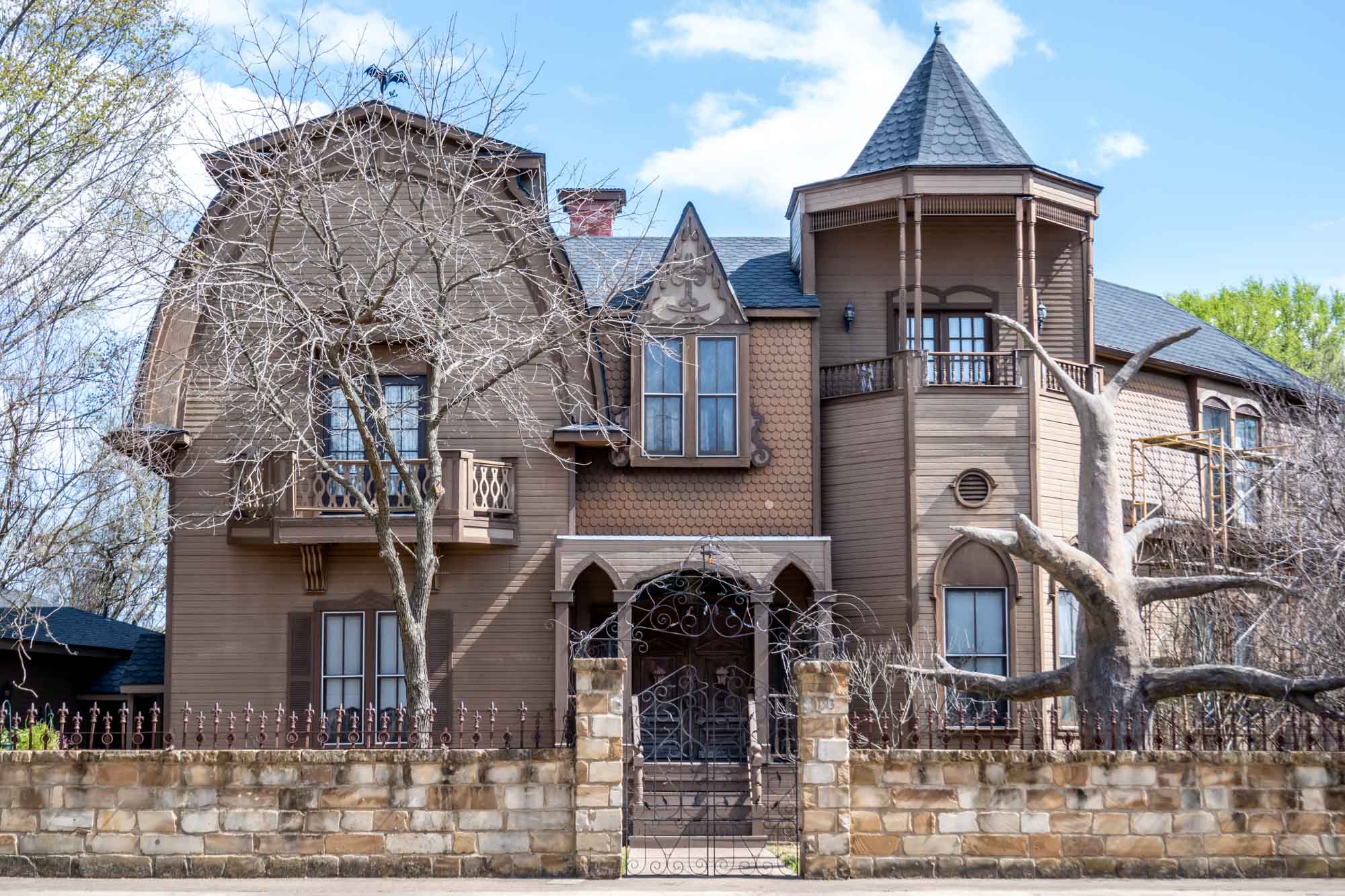 Brown house surrounded by a short stone wall