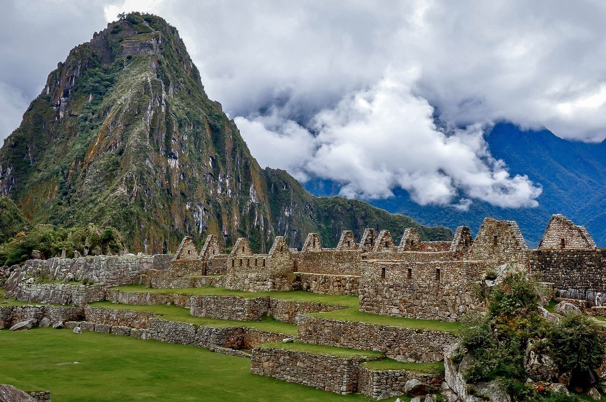 Ruins of stone buildings beside a mountain peak