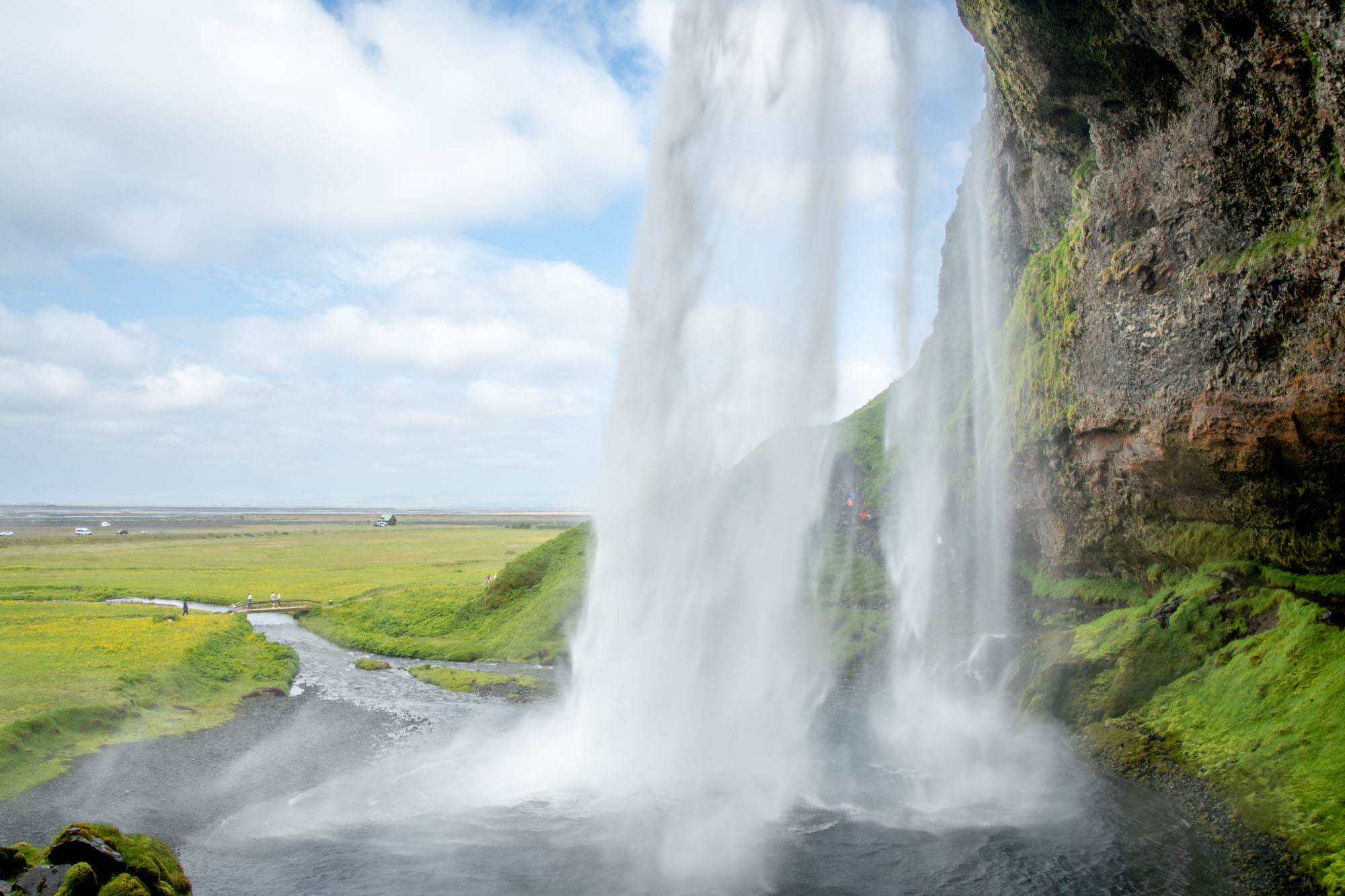 View of a waterfall cascade from behind the falls