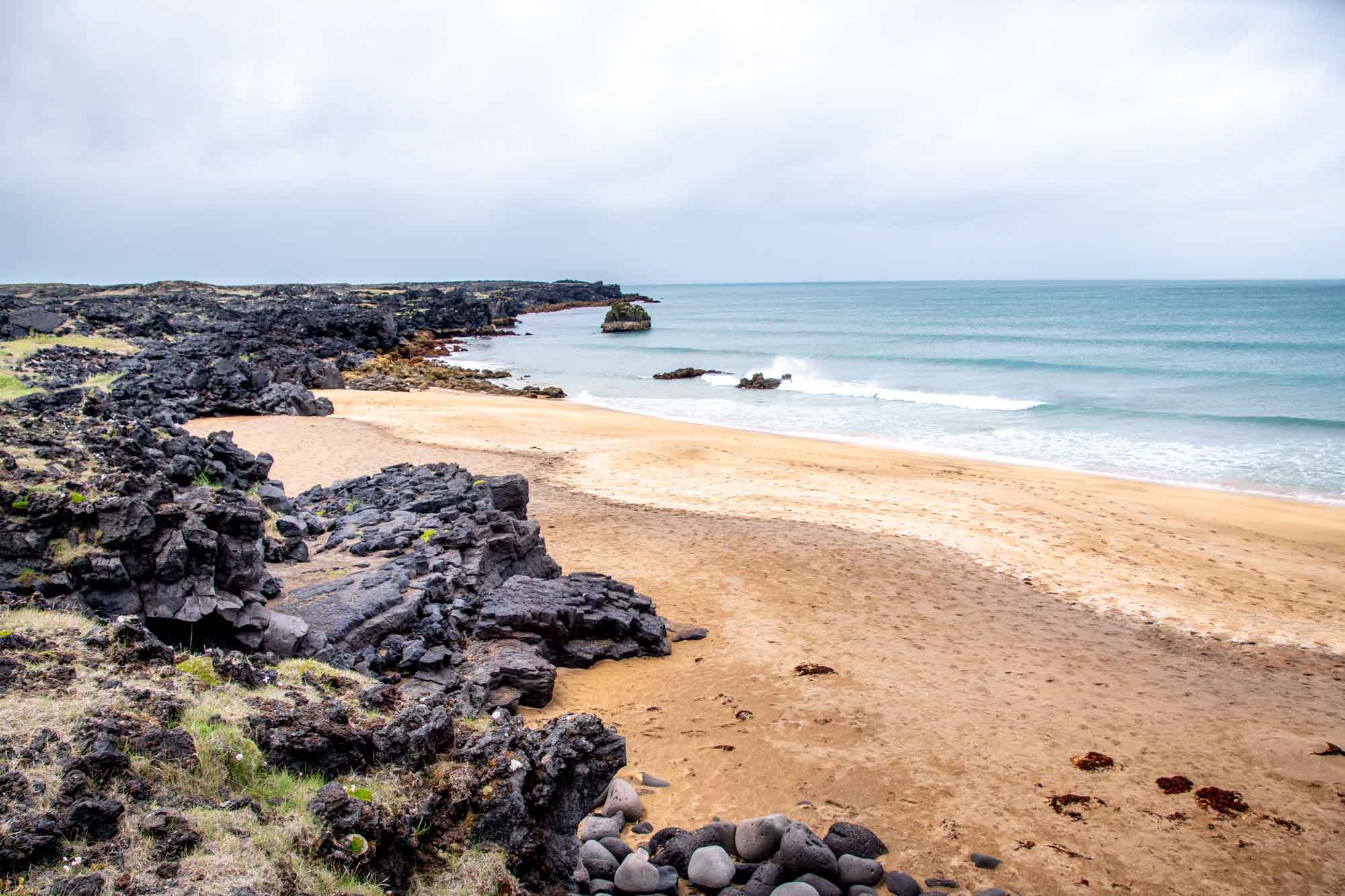 Beach with golden sand and black rocks