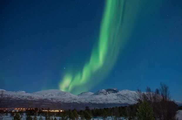 Wisp of green light over a snow-covered mountain