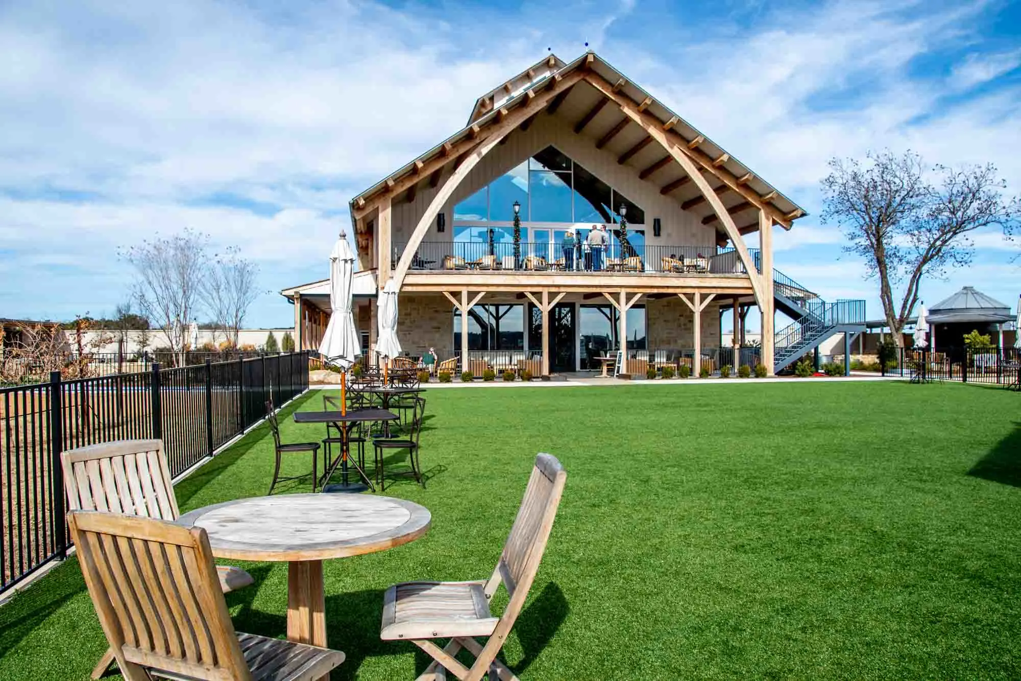 Tables and chairs on the lawn outside a large wooden building