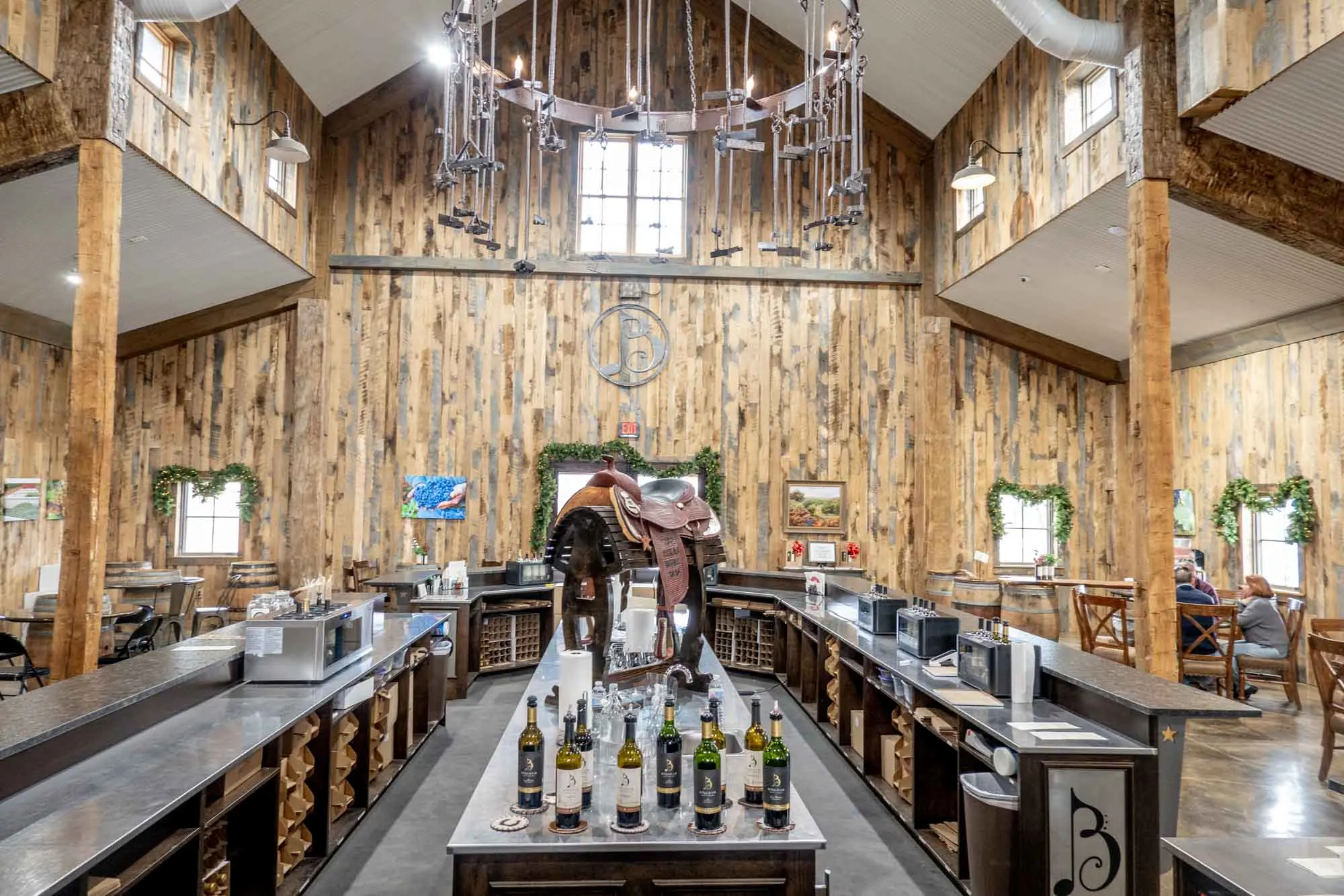 Large room with wood paneling and a bar for wine tasting at the center