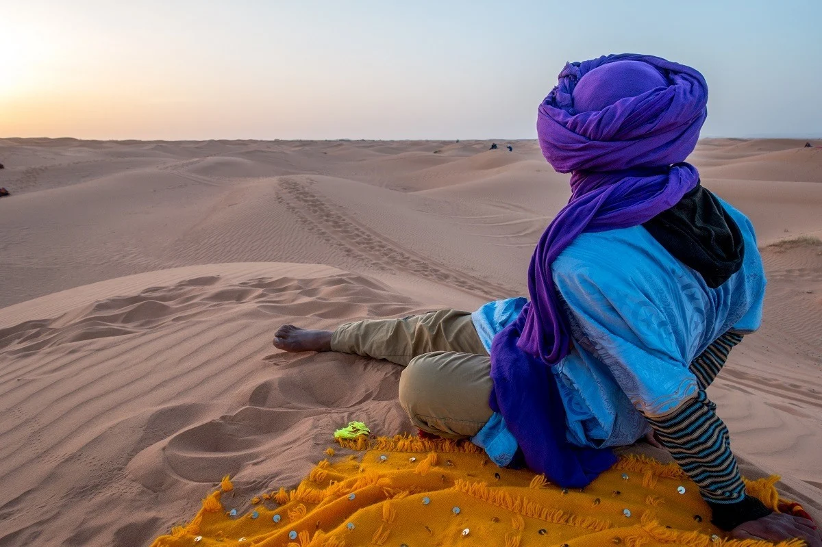 Man looking out over sand dunes