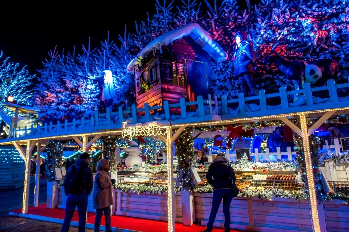 People shopping at highly-decorated market stall.