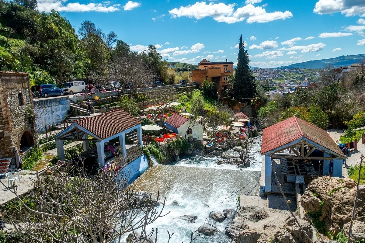 Waterfall and cars on road nearby