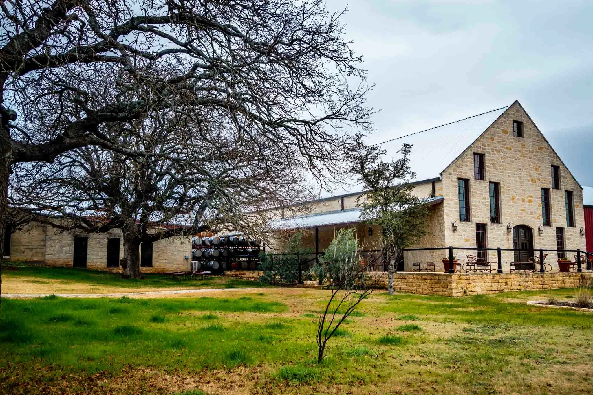 Stone barn with wine barrels stacked outside