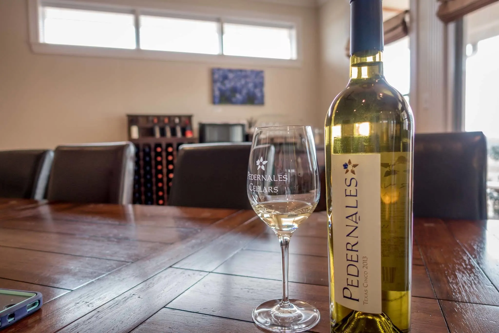 Wine bottle and glass on table at Pedernales Cellars