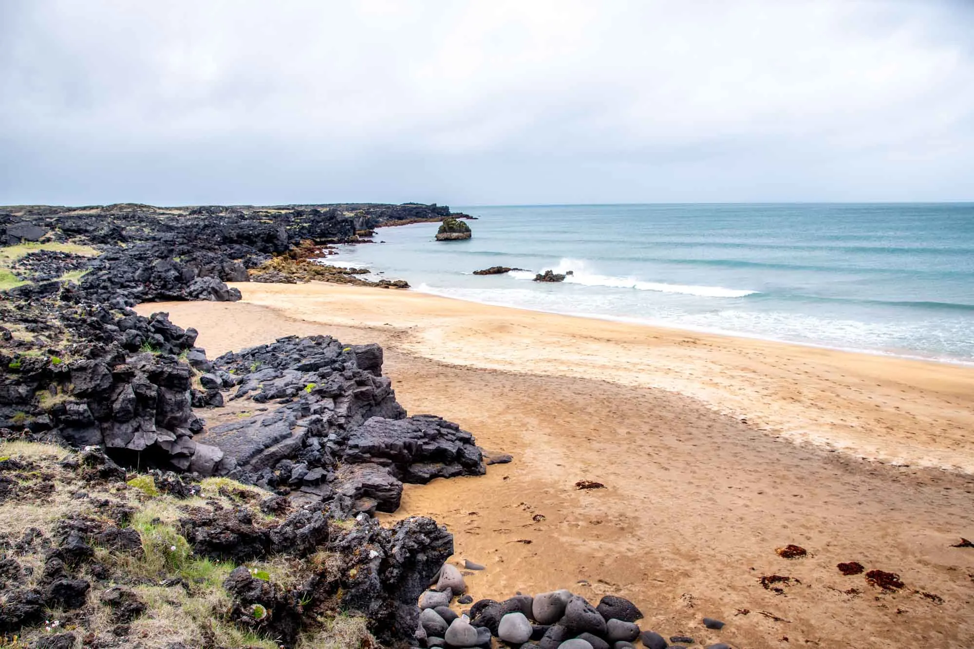 Beach with golden sand and black rocks