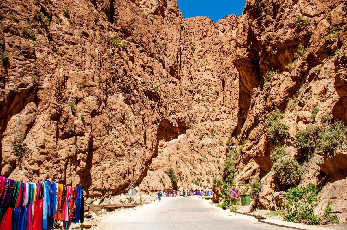 Items for sale along a road surrounded by high mountains