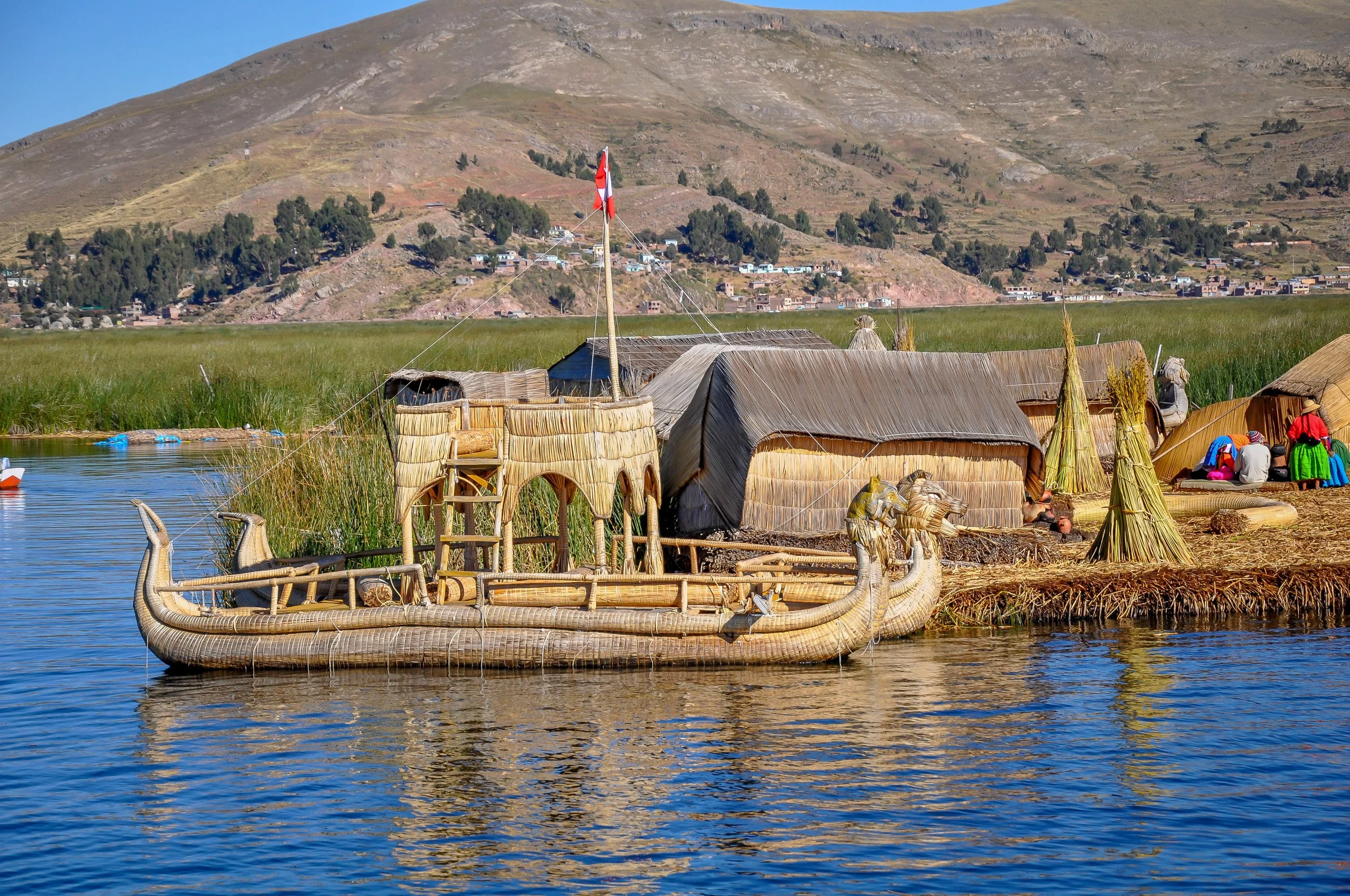 Reed boats beside Islands made of reeds floating in a lake